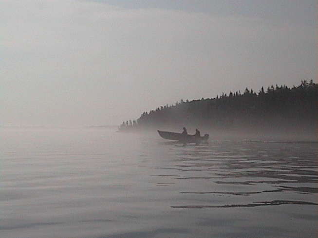This is a photo of a boat heading out for a day of fishing on a cool misty morning