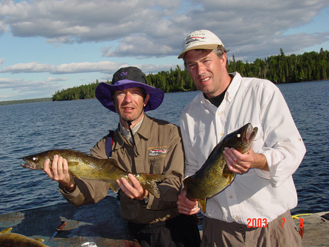 This is a photo of two twin brothers each holding 4 pound Walleyes