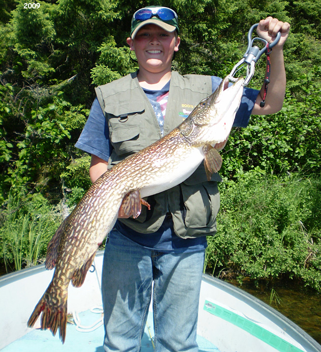 This is a photo of a boy holding a 15 pound Northern Pike
