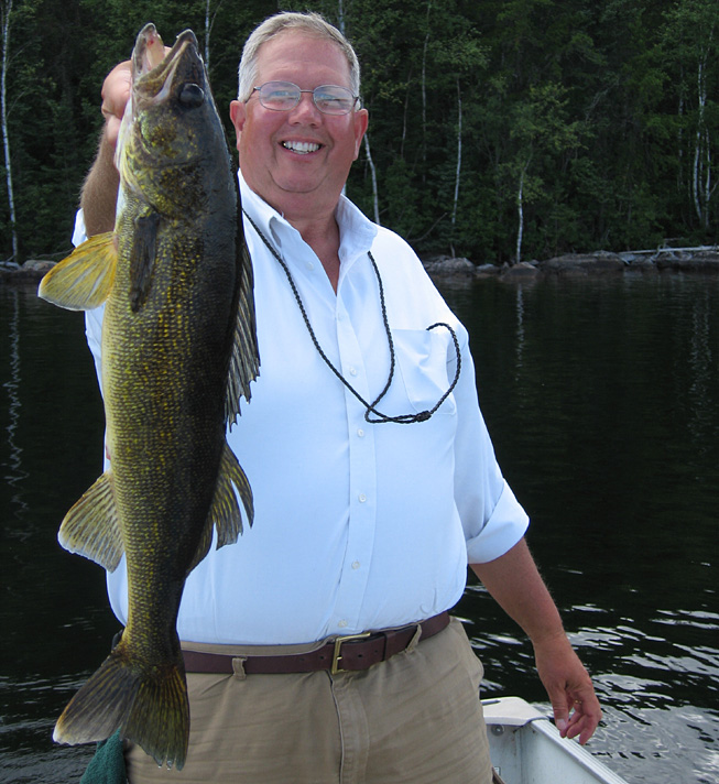 This is a photo of a man holding up a 3 pound walleye